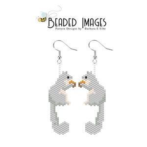 May include: A pair of silver beaded earrings featuring a gray sugar glider holding a nut. The earrings are hanging from silver hooks.