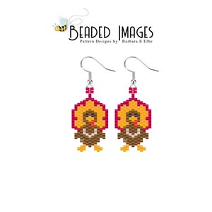 May include: A pair of beaded earrings featuring a turkey design. The turkey is brown, orange, and yellow with a red wattle. The earrings are made with seed beads and have silver hooks.