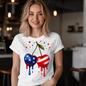 May include: White t-shirt with a patriotic cherry design. One cherry has a blue and white star pattern, the other red and white stripes. Red and blue stars are scattered around the cherries.