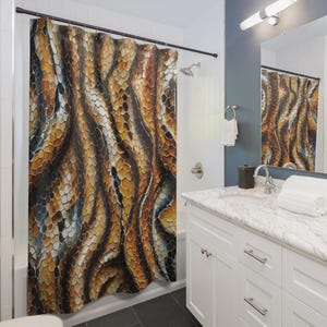 May include: A patterned shower curtain featuring a design reminiscent of snake scales in brown, tan, and black hues. The curtain is displayed in a bathroom with white walls, a white vanity unit, and a dark floor. A mirror reflects the curtain.
