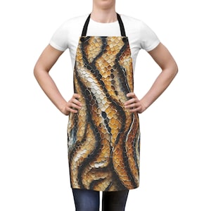 May include: A brown and yellow snakeskin patterned apron with adjustable straps.