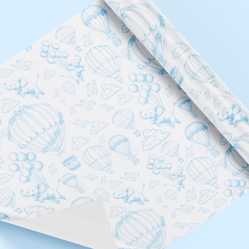May include: Blue and white wrapping paper with a repeating pattern of hot air balloons, elephants, and clouds. The balloons are drawn in a vintage style and have a basket underneath. The elephants are flying in the balloons and holding onto the basket.