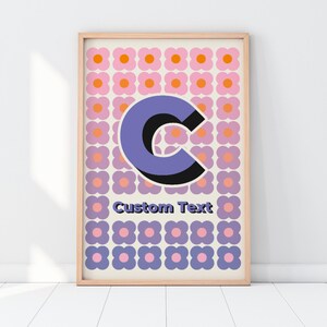 Könnte beinhalten: Ein gerahmter Druck mit einem violetten und schwarzen Buchstaben "C" auf einem Hintergrund aus rosa und violetten Blumen. Der Text "Custom Text" befindet sich unterhalb des Buchstabens.