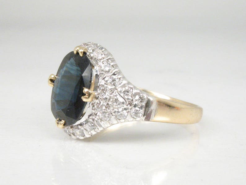 May include: A gold ring with a large oval blue gemstone surrounded by smaller white gemstones.