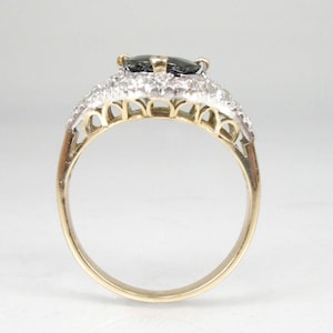 May include: A gold ring with a black gemstone surrounded by smaller white gemstones.