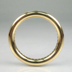 May include: A gold band ring with a smooth, polished finish. The ring is set with a row of small, round stones.