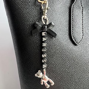 Charm de sac porte-clés personnalisé en perles - Noeud noir, lettres lettres noires et argentées et porte-clés argentés pour un style minimaliste et sophistiqué