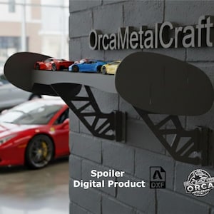 May include: A black metal shelf in the shape of a spoiler, designed to display toy cars. The shelf is mounted on a grey brick wall and holds several toy cars in red, blue, and yellow. The text "OrcaMetalCraft" is above the shelf.