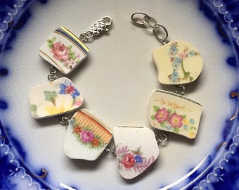May include: A bracelet made from vintage china with floral patterns. The bracelet is connected with silver-toned metal links and a clasp.