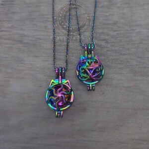 May include: Two iridescent cat-shaped pendant necklaces. The pendants are made of metal and feature intricate cut-out designs. The necklaces hang on delicate chains. The pendants have a rainbow finish, reflecting various colours.