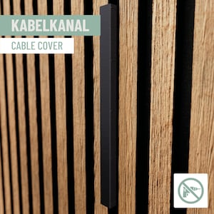 May include: A black cable cover is shown against a backdrop of vertical wooden slats. The text "KABELKANAL" and "CABLE COVER" is displayed in white and green. The image also includes a no-drill icon.