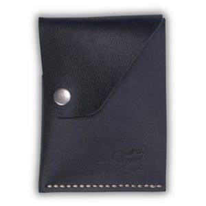 May include: A black leather wallet with a flap closure and a silver button. The wallet has a stitched edge and a small logo on the front.