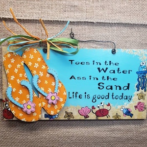 Flip flops hand painted wooden sign toes in the water Ass in the sand.
