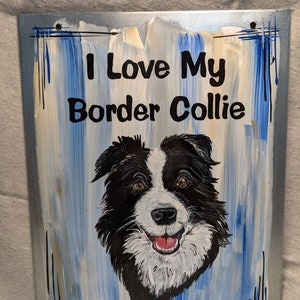 Puede incluir: Letrero de metal pintado con un perro Border Collie y el texto "I Love My Border Collie". El fondo tiene pinceladas azules, blancas y beige. El perro es blanco y negro con ojos marrones y una lengua roja.