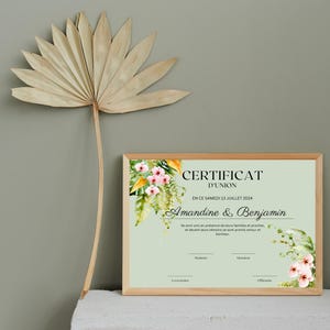 May include: A framed certificate with a green background and floral accents. The text reads "Certificat d'Union" and "En ce samedi 13 juillet 2024" and "Amandine & Benjamin".