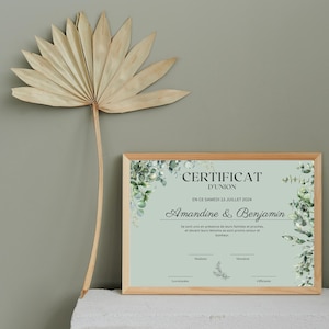 May include: A framed certificate with a green and white floral design. The text on the certificate reads "Certificat d'Union" and "En ce samedi 13 juillet 2024" and "Amandine & Benjamin".