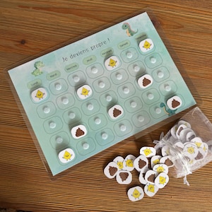 Peut inclure: Un tableau de propreté pour enfant avec le texte "Je deviens propre !" et des illustrations de dinosaures. Comprend une grille avec des espaces pour les autocollants, un sac d'autocollants et un fond en bois.