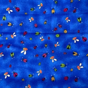 May include: Blue fabric with a repeating pattern of red, yellow and black ladybirds and bees.