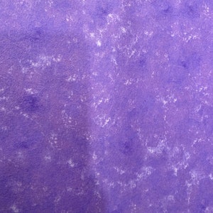 May include: A textured, purple surface with white, irregular blotches. The background is a solid, medium purple color. The white blotches are scattered across the surface, creating a mottled effect.