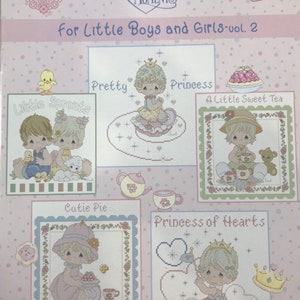 Può includere: Una collezione di 14 schemi di ricamo a punto croce con personaggi Precious Moments. Gli schemi includono "Little Sprouts", "Pretty", "Princess", "A Little Sweet Tea", "Cutie Pie" e "Princess of Hearts".
