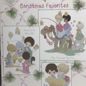 K&ouml;nnte beinhalten: Ein Stickmusterheft mit drei Weihnachtsmotiven von Precious Moments. Die Motive sind "Kommt, lasst uns ihn anbeten", "Sie folgten dem Stern" und "Sein Name ist Jesus".