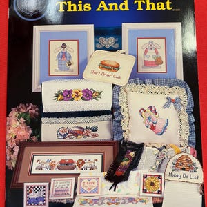May include: A cross stitch pattern booklet titled "This And That" with a variety of cross stitch designs, including a bunny, a heart, a sandwich, a flower, a pillow, a beehive, and a sunflower. The booklet is from C.O.S.S. M.Y. H.E.A.R.T., INC. and is dated 1995.