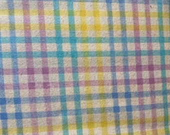 May include: A close-up of a fabric with a checkered pattern in shades of blue, yellow, and purple.