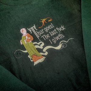 Può includere: Felpa verde scuro con ricami in stile medievale. Il design presenta una figura con un lungo abito verde e arancione, con la scritta "thar goes! The last f*ck I giveth."