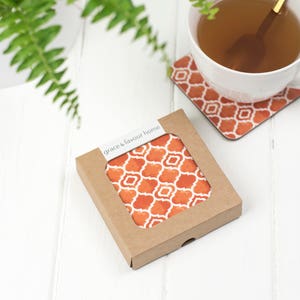 May include: A set of four orange and white patterned coasters in a brown cardboard box with the text "grace & favour home".