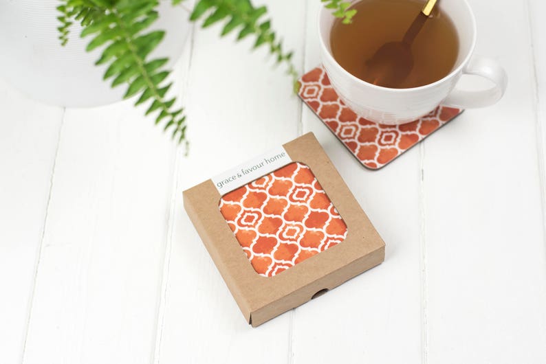 May include: A set of four orange and white patterned coasters in a brown cardboard box with the text "grace & favour home".