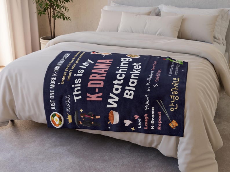 Cozy K-Drama Watching Blanket on a bed, featuring fun quotes like "Just One More K-Drama Episode!" and graphics of Korean food, soju, and a K-drama couple.
