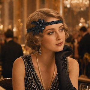 May include: A black beaded headband featuring a floral design with sequins and a central crystal accent. The band is constructed from a dark fabric with intricate embroidery and beadwork, designed to be worn across the forehead.
