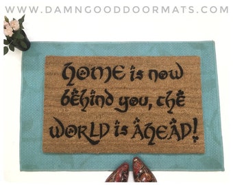 Cita de Tolkien El hogar ahora está detrás de ti, el mundo está por delante Gandalf geek doormat puerta mat geek nerd regalos nueva casa