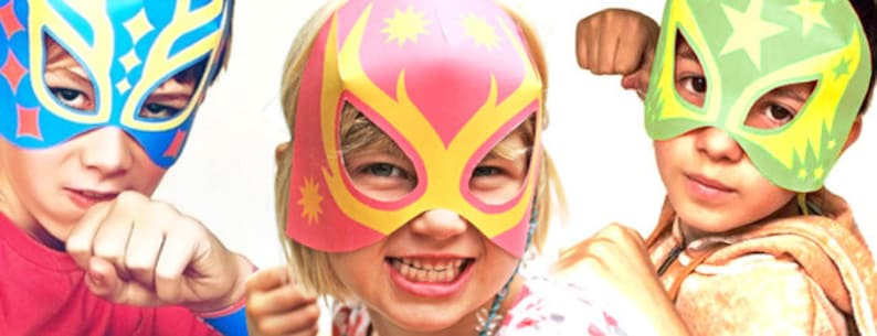 May include: Three children wearing colorful wrestling masks. The masks are made of paper and have a star design. The children are smiling and looking at the camera.