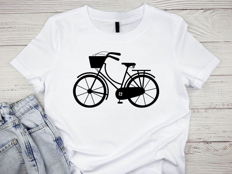 K&ouml;nnte beinhalten: Ein wei&szlig;es T-Shirt mit einer schwarzen Silhouette eines Fahrrads mit einem Korb vorne.