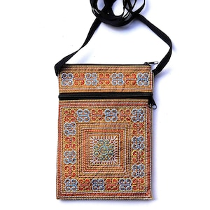 Puede incluir: Bolso bandolera rectangular marr&oacute;n con cremallera y correa negras. El bolso presenta un dise&ntilde;o bordado detallado en rojo, azul y amarillo. La correa es un simple cord&oacute;n negro.