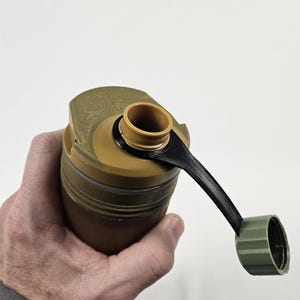 May include: A green and brown water bottle with a black carrying strap and a green cap. The bottle has a textured surface and a wide mouth opening.