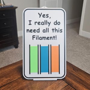 May include: White sign with black text that reads "Yes, I really do need all this Filament!" with a graphic of four colored filament spools.