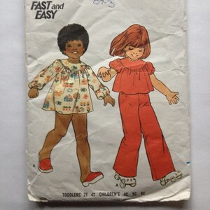 Può includere: Un modello di cucito vintage per un abito da bambina. Il modello è per un vestito e pantaloni con stampa floreale. Il modello è di Butterick ed è taglia 5. Il modello si chiama "Fast and Easy" ed è stato disegnato da Elizabeth Strok.