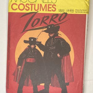 May include: A vintage McCall's Costumes sewing pattern featuring a Zorro costume design. The package has a yellow top with the word "COSTUMES" and the Zorro title in large black letters. The image shows two figures in black Zorro outfits with red capes.