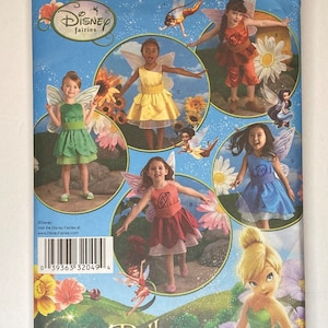 May include: A Simplicity sewing pattern for a Tinkerbell costume. The pattern includes instructions for making a dress, wings, and a headband. The pattern is for sizes 3-8. The pattern cover features a photo of Tinkerbell and several girls wearing the costume.