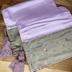 Platinum brocaded satin makeup bag with tassel zipper pull
