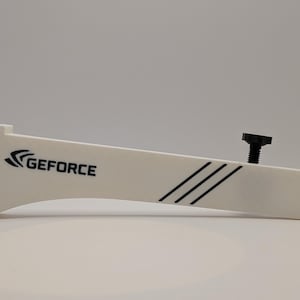 Op de afbeelding: Een witte GeForce-beugel met zwarte accenten en een zwarte schroef. De beugel heeft drie zwarte diagonale lijnen en het GeForce-logo. Ontworpen voor computercomponenten.