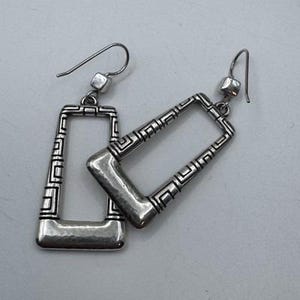 May include: A pair of silver-toned rectangular earrings. The earrings have a geometric design with a hammered finish on the bottom. The earrings have a hook closure.