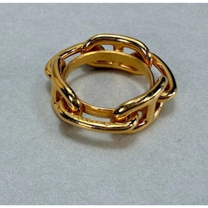 May include: A gold-toned ring featuring a continuous chain-link design. The band is composed of interconnected, polished oval links that form a circular shape, creating a uniform and metallic appearance throughout the entire piece of jewelry.
