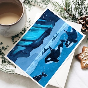 May include: A watercolor painting of a family of orcas swimming in the ocean at night. The orcas are black and white, and the water is a deep blue. The background is a dark blue sky with stars.