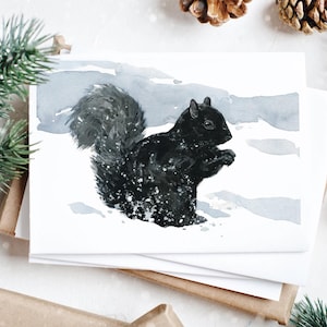 Tarjeta de invierno con ardilla negra. Tarjeta navideña con vida silvestre en la nieve.