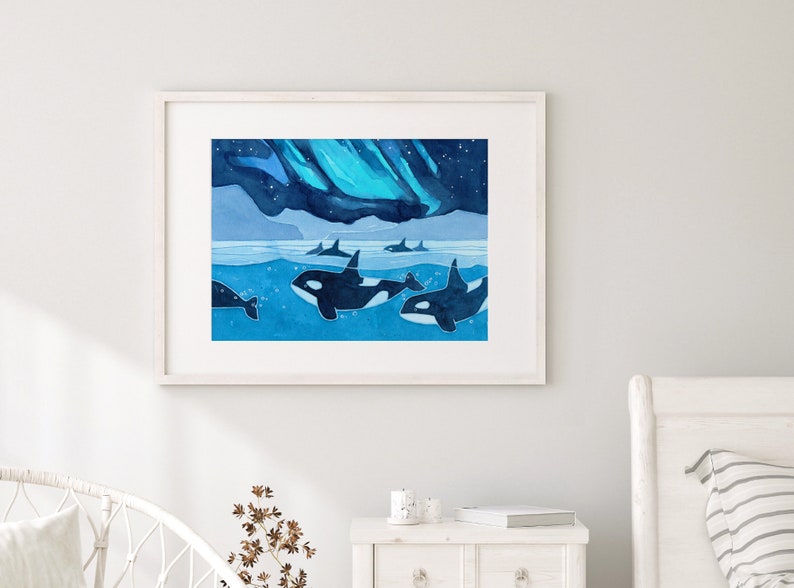 May include: A watercolor painting of a pod of orcas swimming in the ocean under a blue and green aurora borealis. The orcas are black and white and the water is a deep blue.
