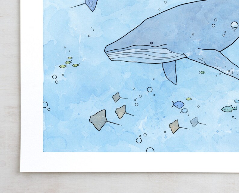 May include: A watercolor painting of a blue whale swimming in the ocean with a school of small fish and stingrays. The background is a light blue watercolor wash.