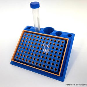 Puede incluir: Un soporte de tubos de laboratorio azul y naranja con una configuración de 96 pocillos. Un tubo transparente con una tapa azul se inserta en el soporte, junto con varios tubos pequeños y transparentes. El soporte está diseñado para contener varios tubos.